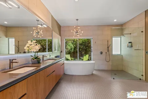 a bathroom with a double vanity sink a large mirror and shower