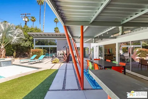 a view of swimming pool with lawn chairs and a big yard