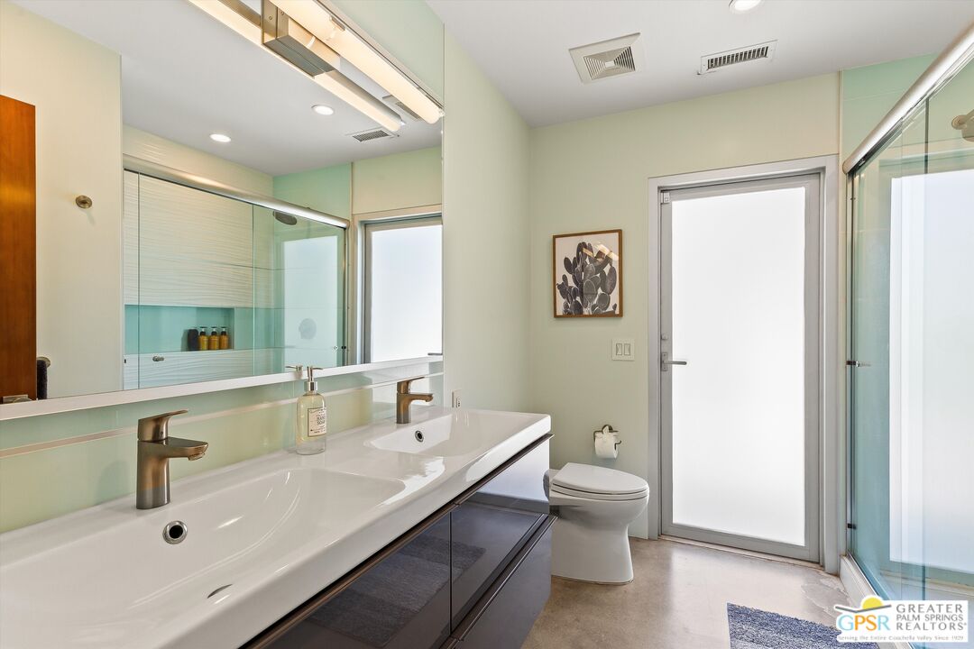 1349 Sagebrush Road Palm Springs, CA 92264 - Photo 41 of 61 a bathroom with a double vanity sink toilet mirror and bathtub