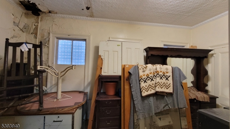 221 Spring Street Paterson, NJ 07503 - Photo 22 of 30 a bed sitting in a bedroom next to a window