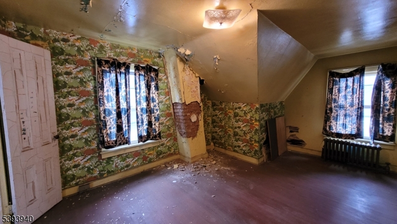 221 Spring Street Paterson, NJ 07503 - Photo 26 of 30 a view of an empty room with stairs and wooden floor