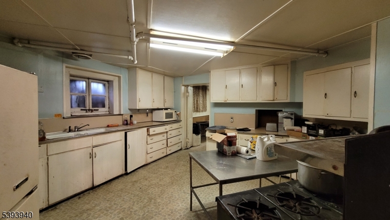 221 Spring Street Paterson, NJ 07503 - Photo 9 of 30 a living room with furniture a fireplace and a chandelier