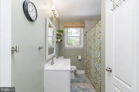 a bathroom with a granite countertop sink a toilet and a mirror