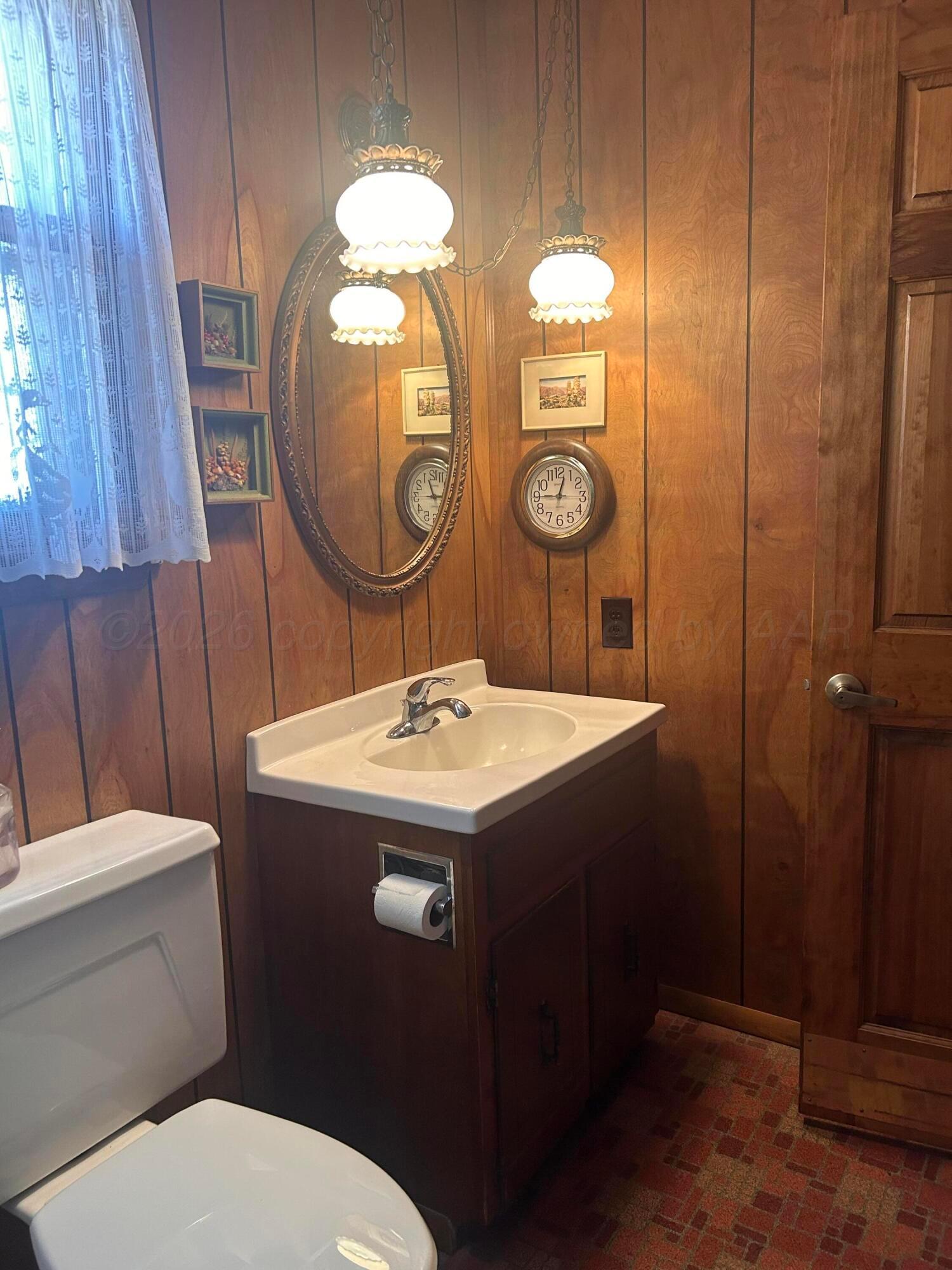 216 North 7th Street Canadian, TX 79014 - Photo 29 of 35 a bathroom with a toilet sink and mirror