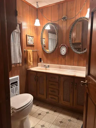 a bathroom with a toilet a sink and a mirror