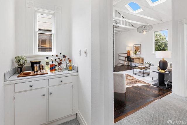a kitchen with white cabinets and window
