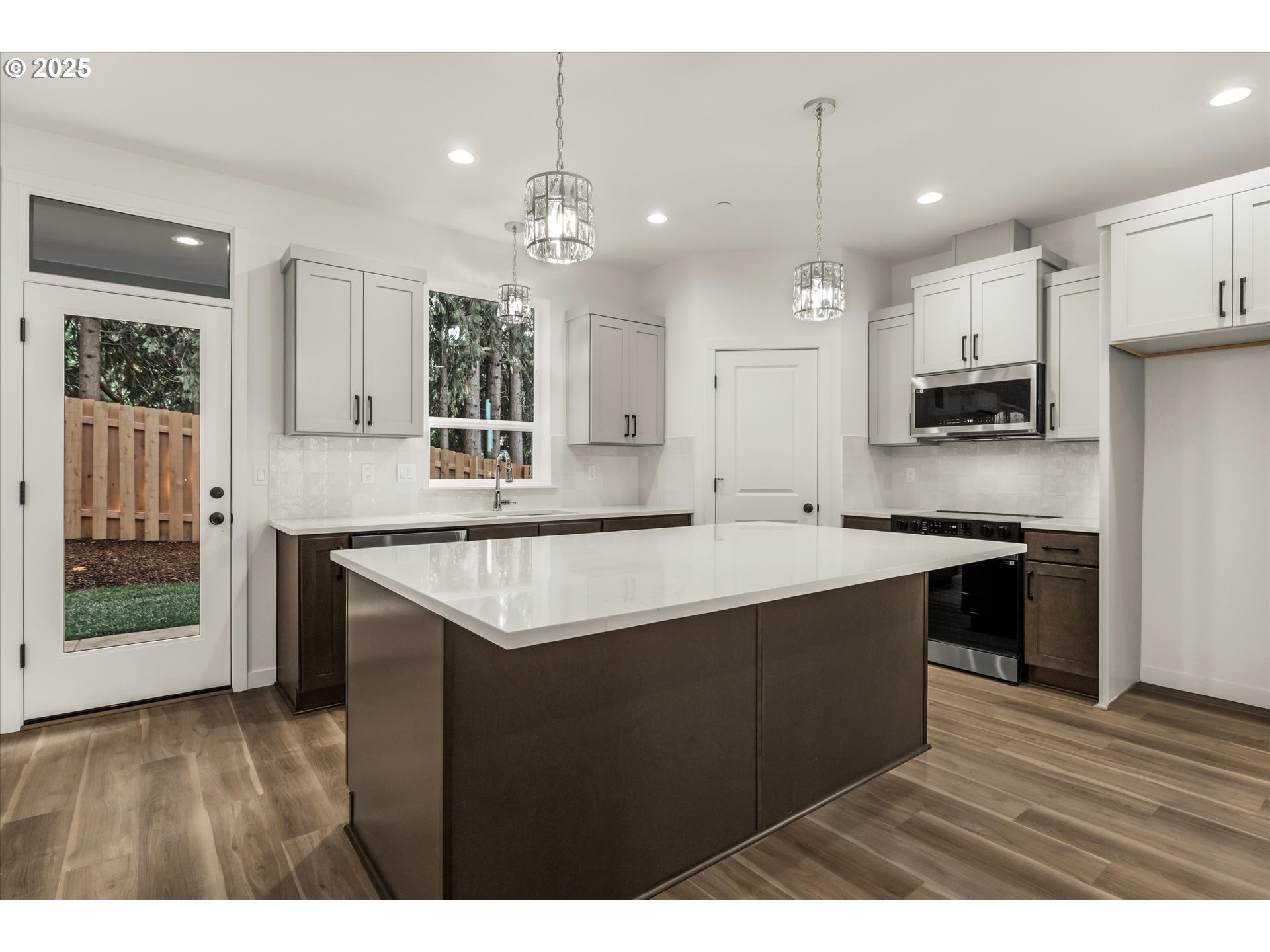 284 Northwest Mawrcrest Drive Gresham, OR 97030 - Photo 9 of 37 a kitchen with kitchen island granite countertop a sink cabinets and wooden floor