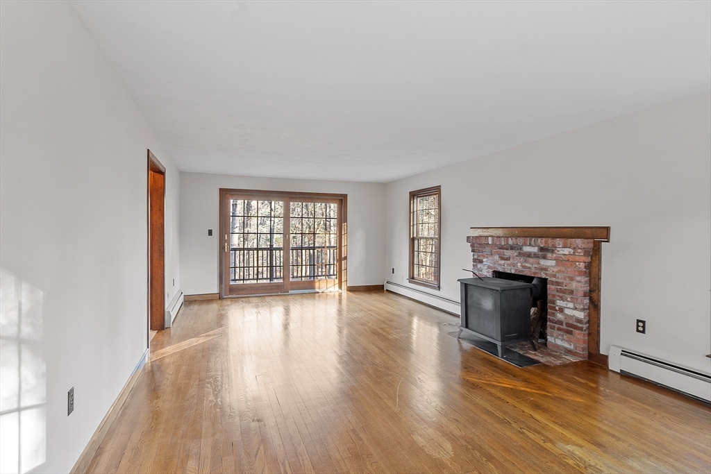 31 Mohawk Road Andover, MA 01810 - Photo 14 of 33 wooden floor fireplace and windows in an empty room