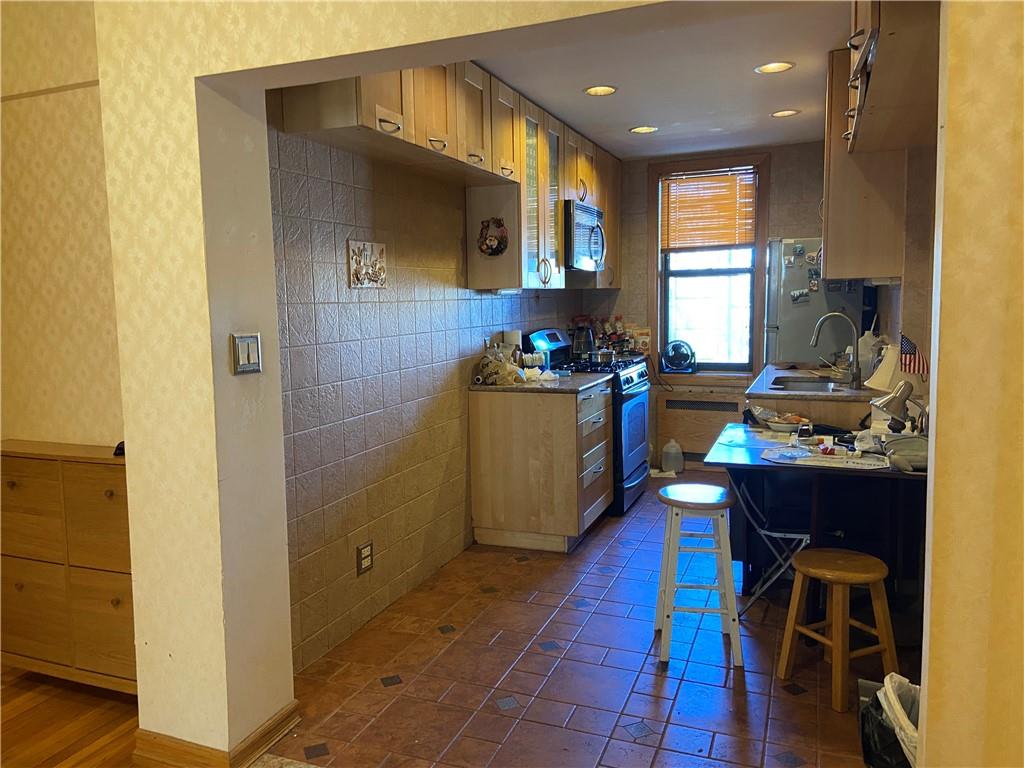 7259 Shore Road, Unit 2K Brooklyn, NY 11209 - Photo 14 of 19 a kitchen with sink refrigerator and stove