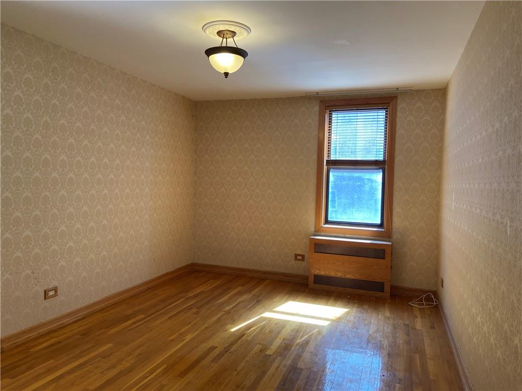 7259 Shore Road, Unit 2K Brooklyn, NY 11209 - Photo 9 of 19 an empty room with wooden floor and windows