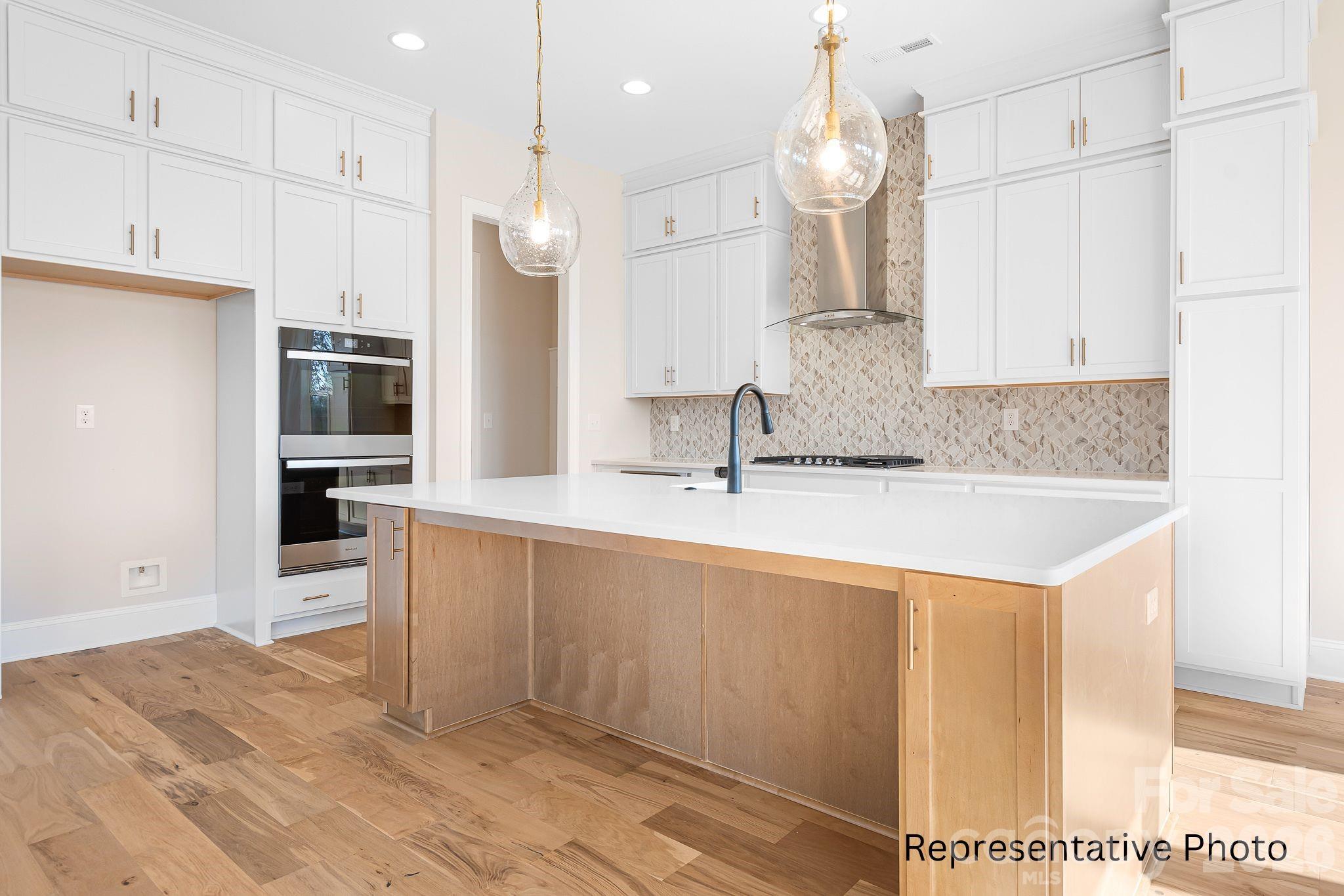 4172 Millstream Road, Unit 137 Denver, NC 28037 - Photo 3 of 28 a kitchen with kitchen island granite countertop a sink and refrigerator