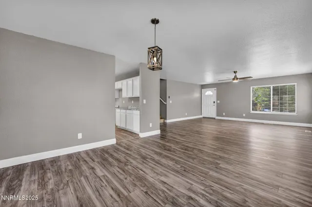 a view of empty room with wooden floor and window