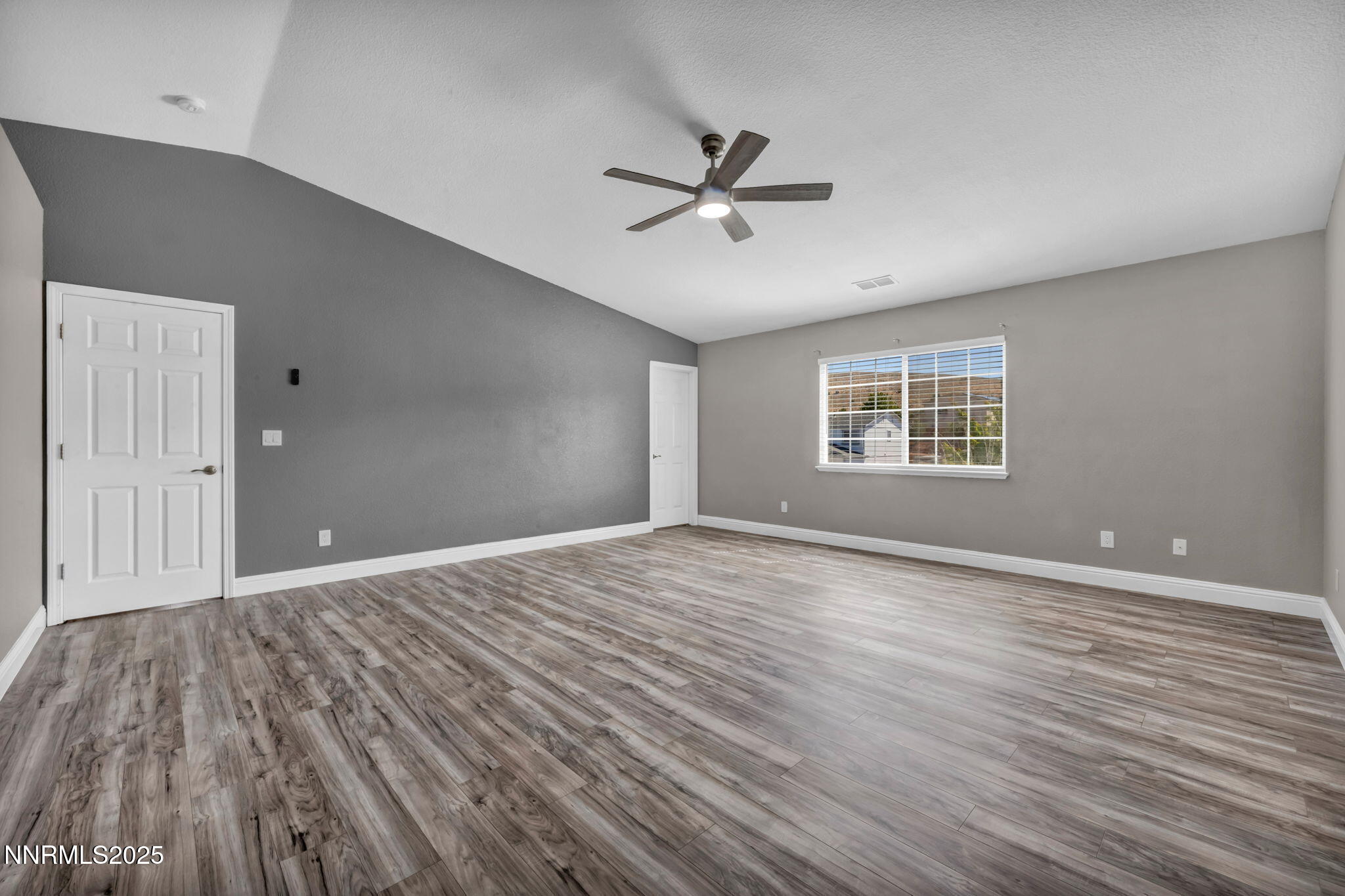 17391 Crystal Canyon Boulevard Reno, NV 89508 - Photo 19 of 63 a view of an empty room with a window and wooden floor