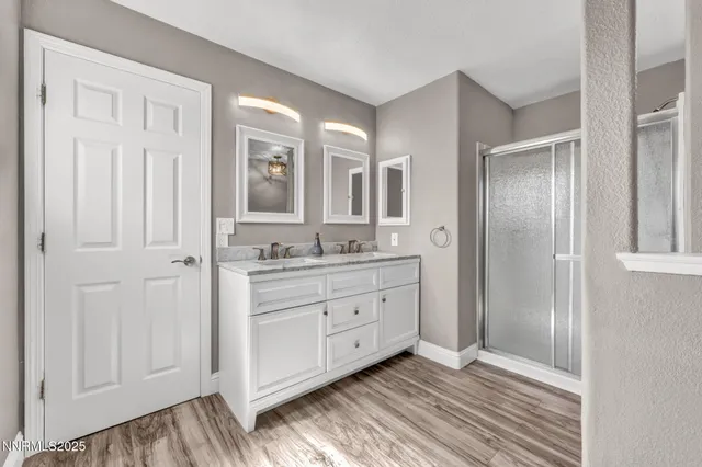 a bathroom with cabinets two sinks and a window
