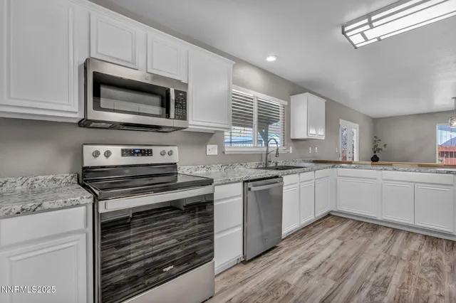 a kitchen with granite countertop cabinets stainless steel appliances and a counter space