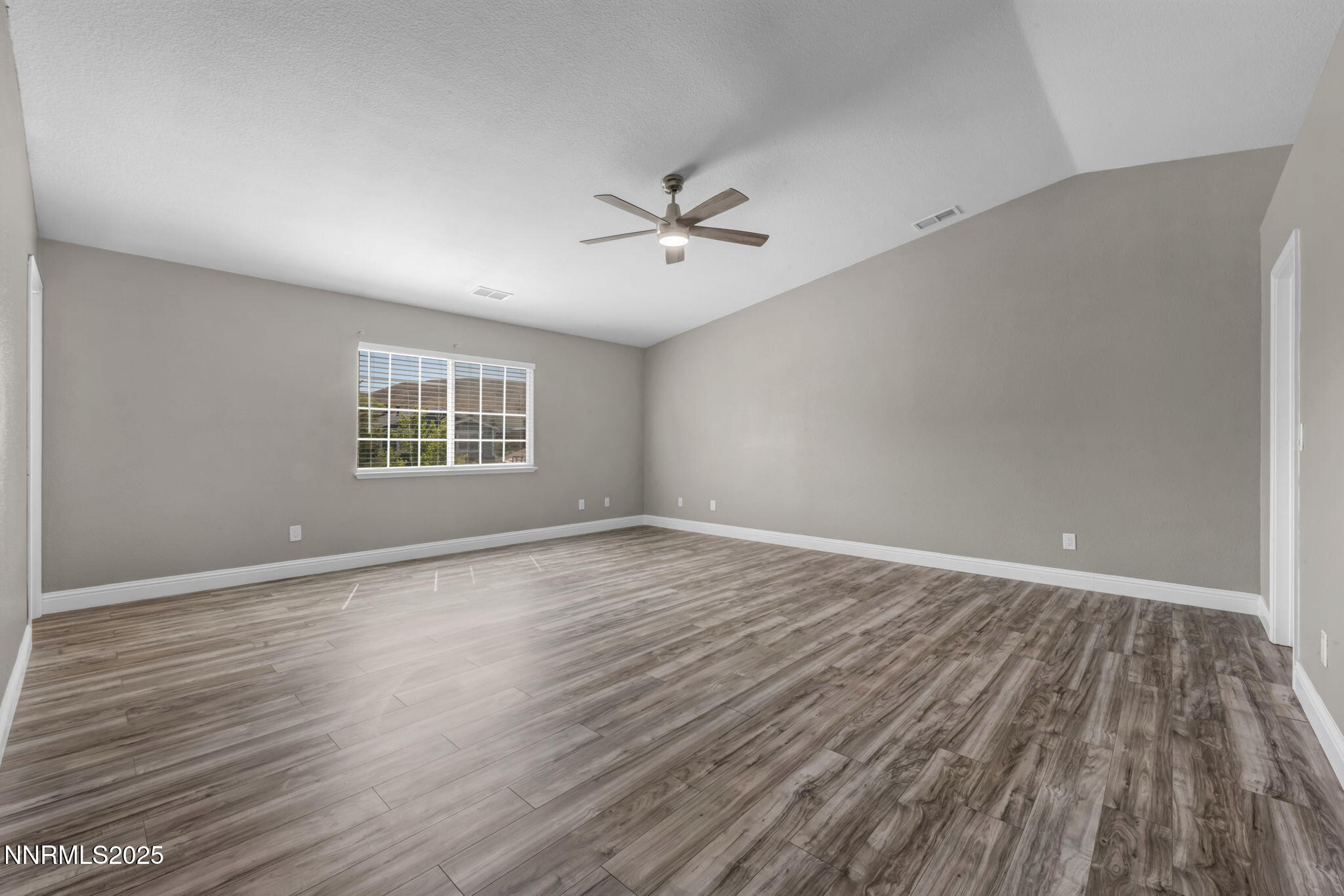 17391 Crystal Canyon Boulevard Reno, NV 89508 - Photo 41 of 63 an empty room with wooden floor ceiling fan and windows