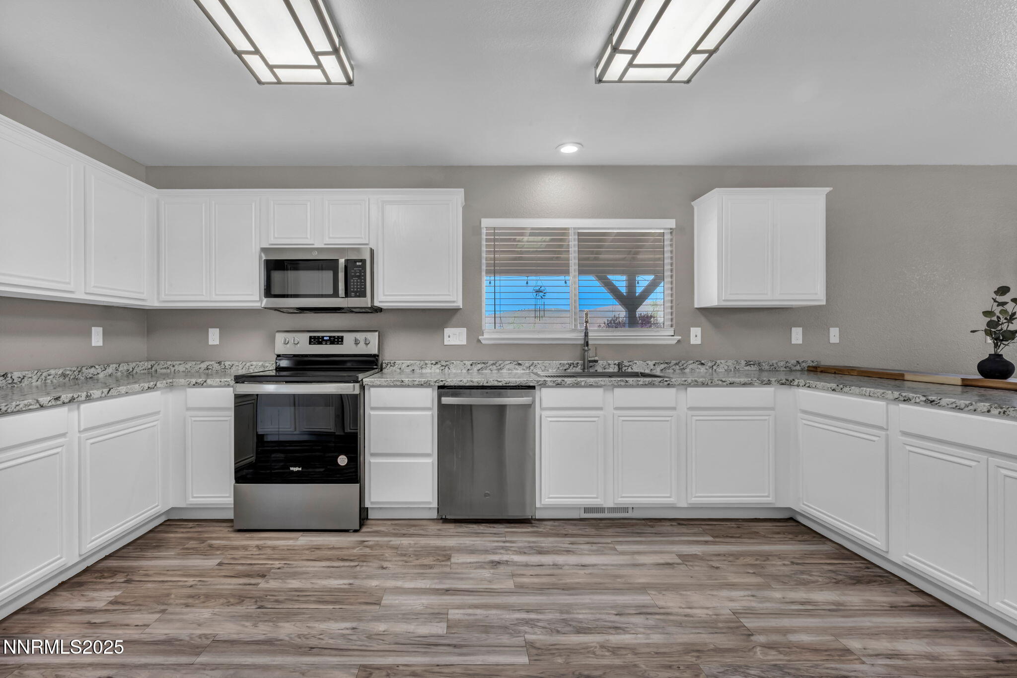 17391 Crystal Canyon Boulevard Reno, NV 89508 - Photo 6 of 63 a kitchen with granite countertop a stove top oven a sink dishwasher a microwave oven and a refrigerator with wooden cabinets