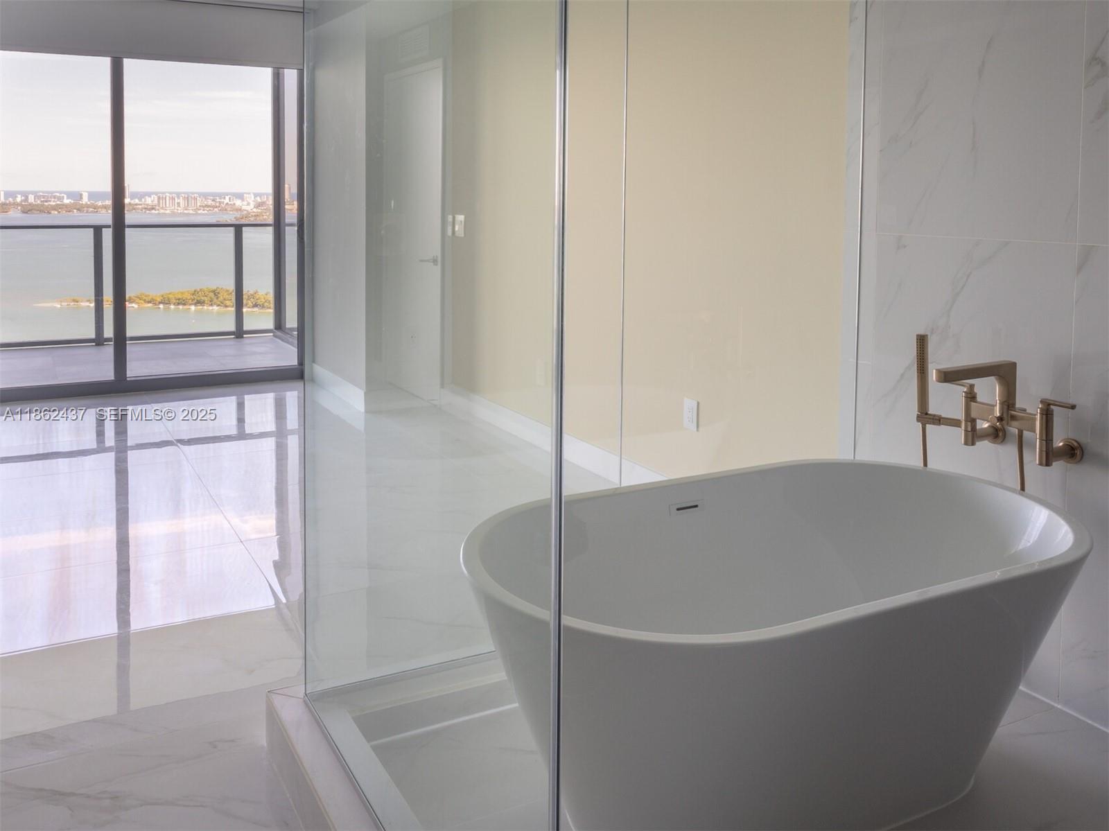 700 Northeast 24th Street, Unit 3304 Miami, FL 33137 - Photo 13 of 64 a white bath tub sitting next to a window