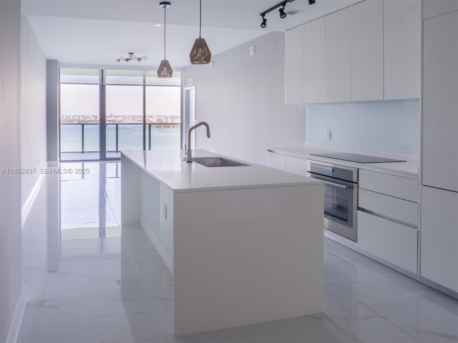 700 Northeast 24th Street, Unit 3304 Miami, FL 33137 - Photo 3 of 64 a kitchen that has a sink a stove and cabinets