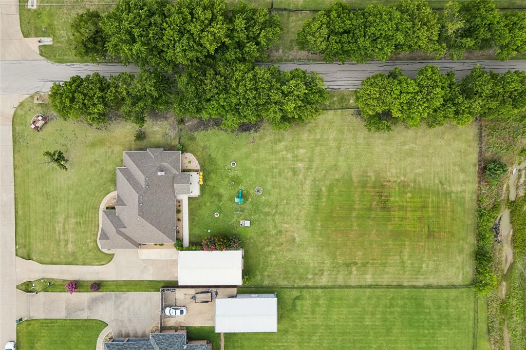 11211 Emerald Ranch Lane Forney, TX 75126 - Photo 9 of 35 Expansive lot featuring a residential structure with a shingled roof, a paved driveway, and a detached carport