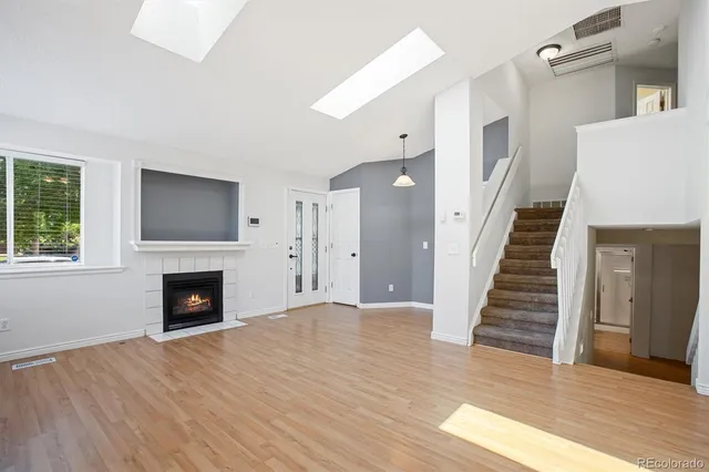 a view of a livingroom with wooden floor and a fireplace