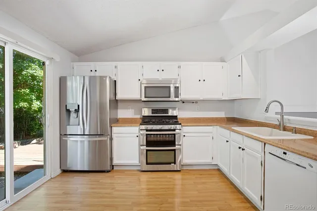a kitchen with white cabinets and stainless steel appliances