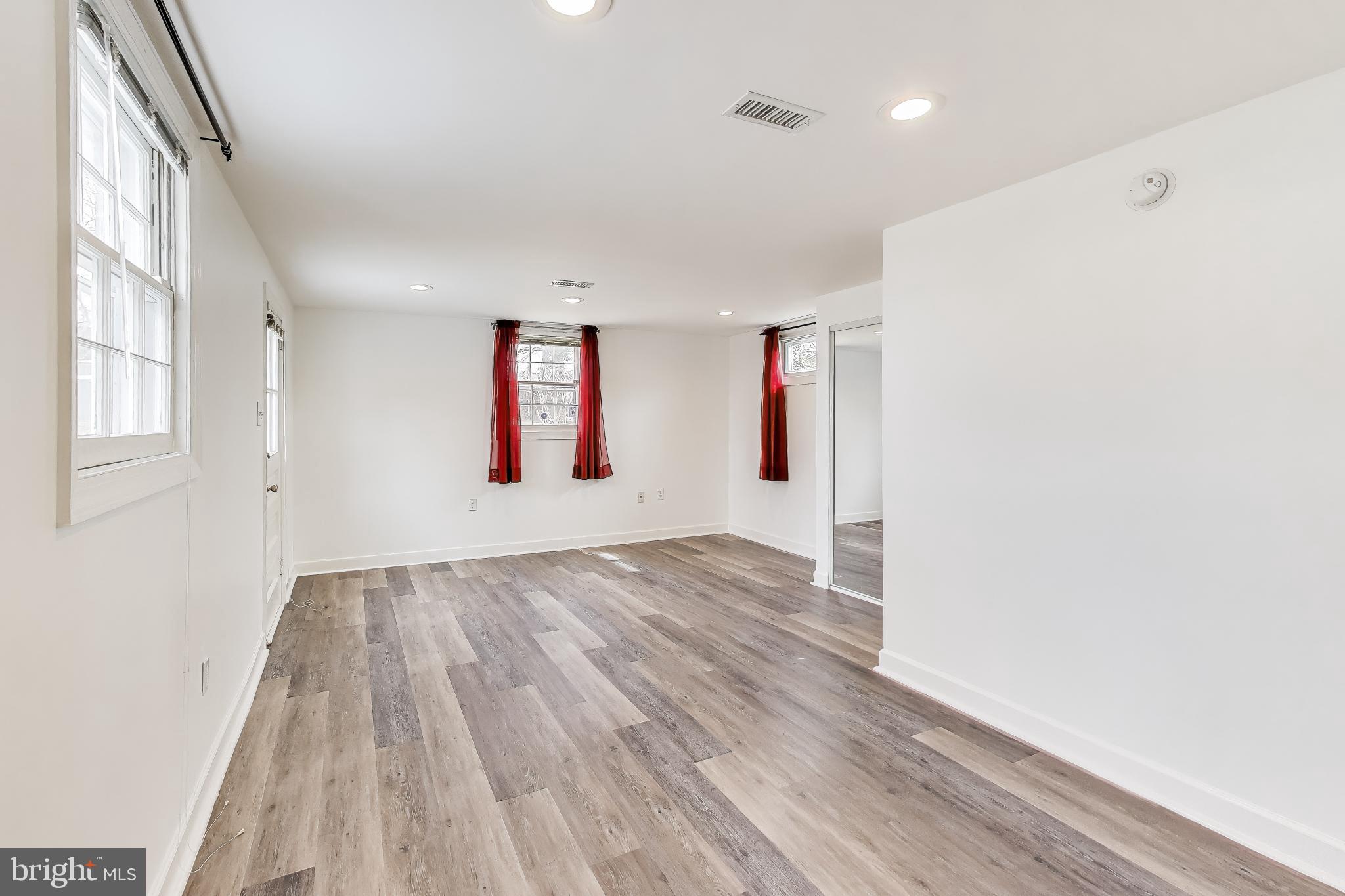 12609 Holdridge Road Silver Spring, MD 20906 - Photo 14 of 30 an empty room with wooden floor and windows