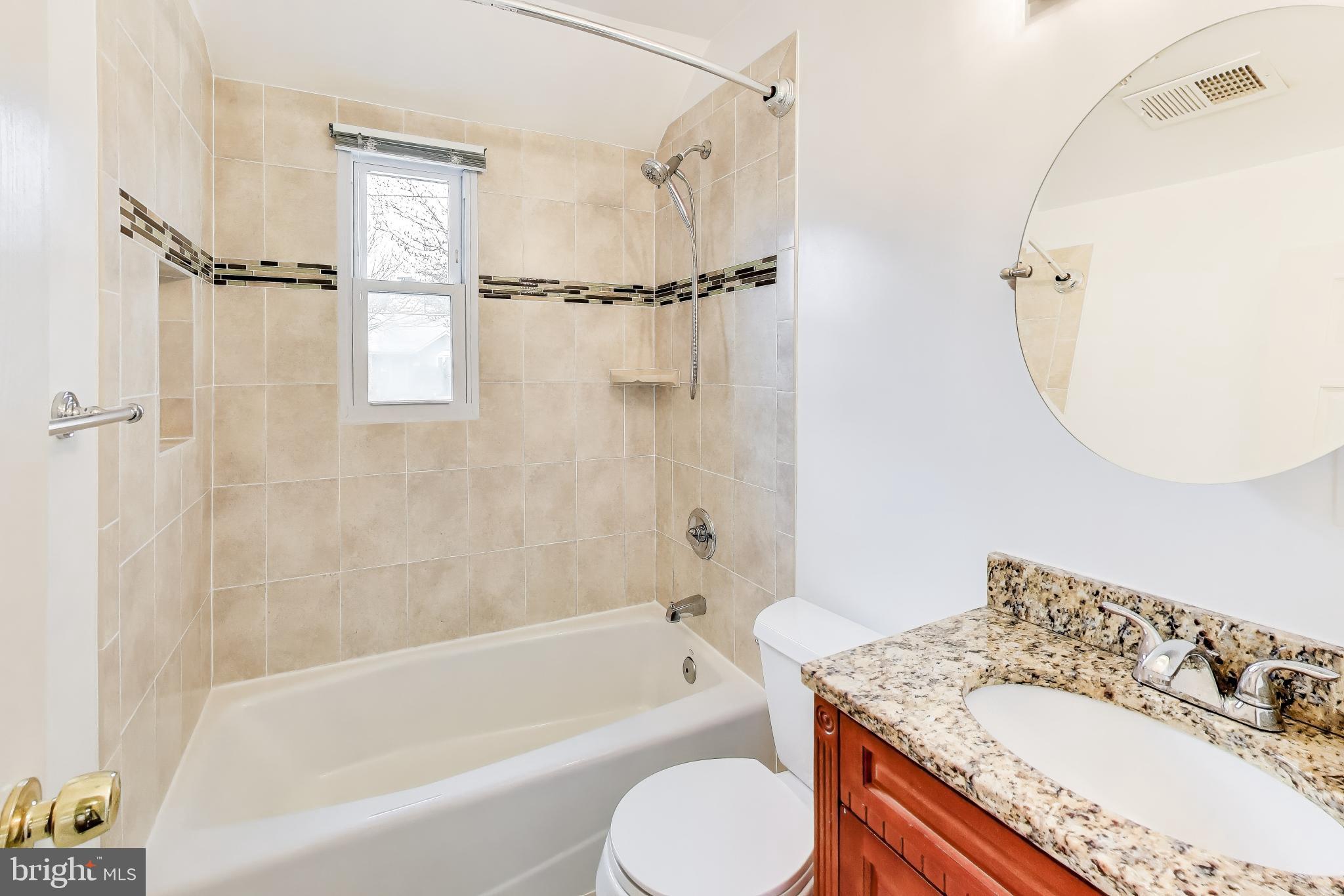 12609 Holdridge Road Silver Spring, MD 20906 - Photo 20 of 30 a bathroom with a granite countertop tub sink a mirror a vanity and a shower