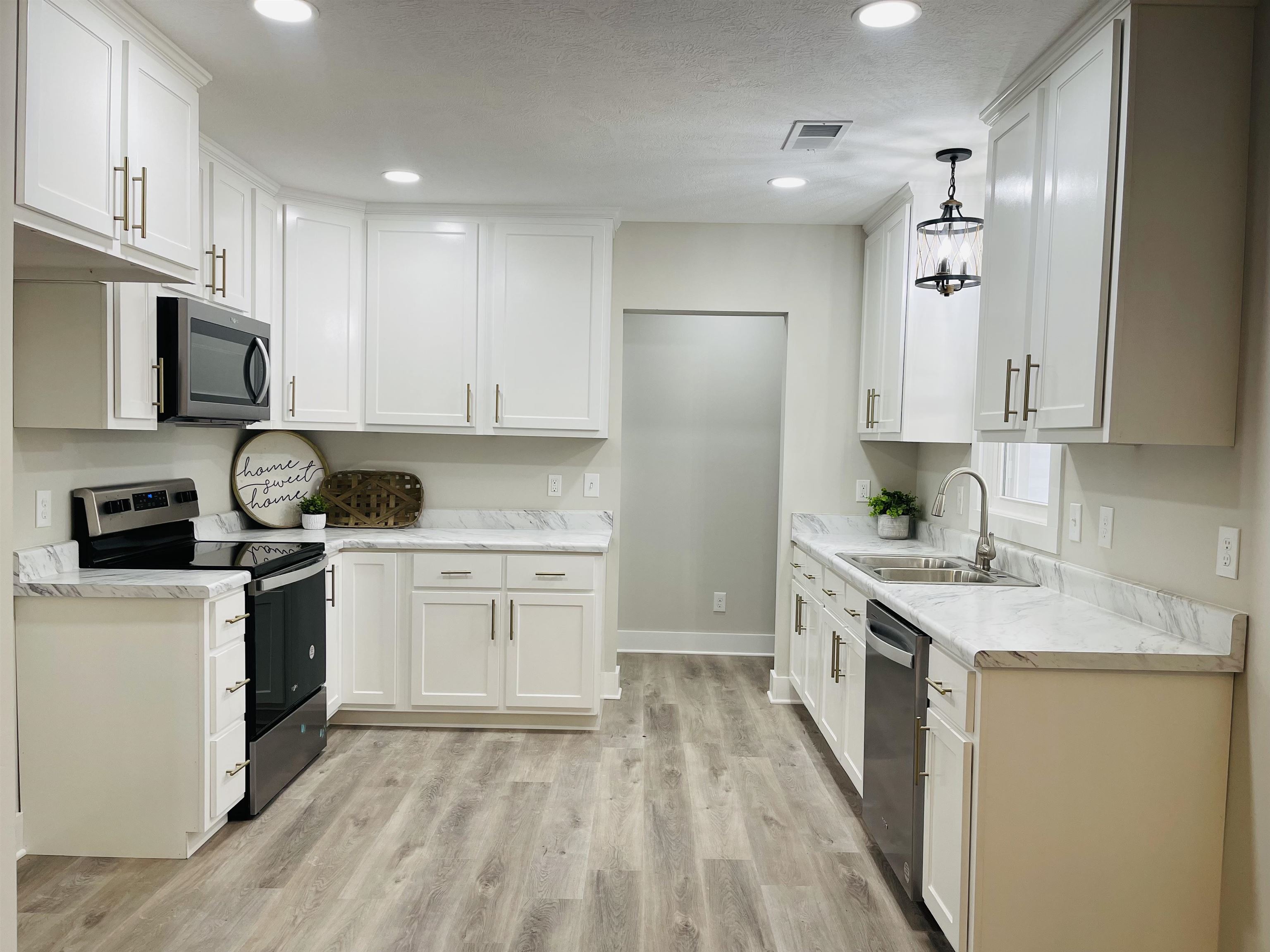 6490 Highway 226 Savannah, TN 38372 - Photo 7 of 38 a kitchen with granite countertop a sink stove a refrigerator and white cabinets