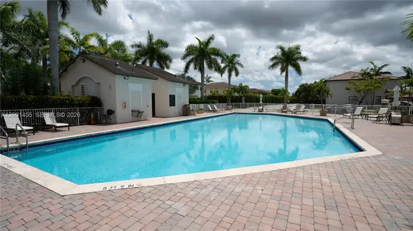a view of swimming pool with outdoor seating and house in the background