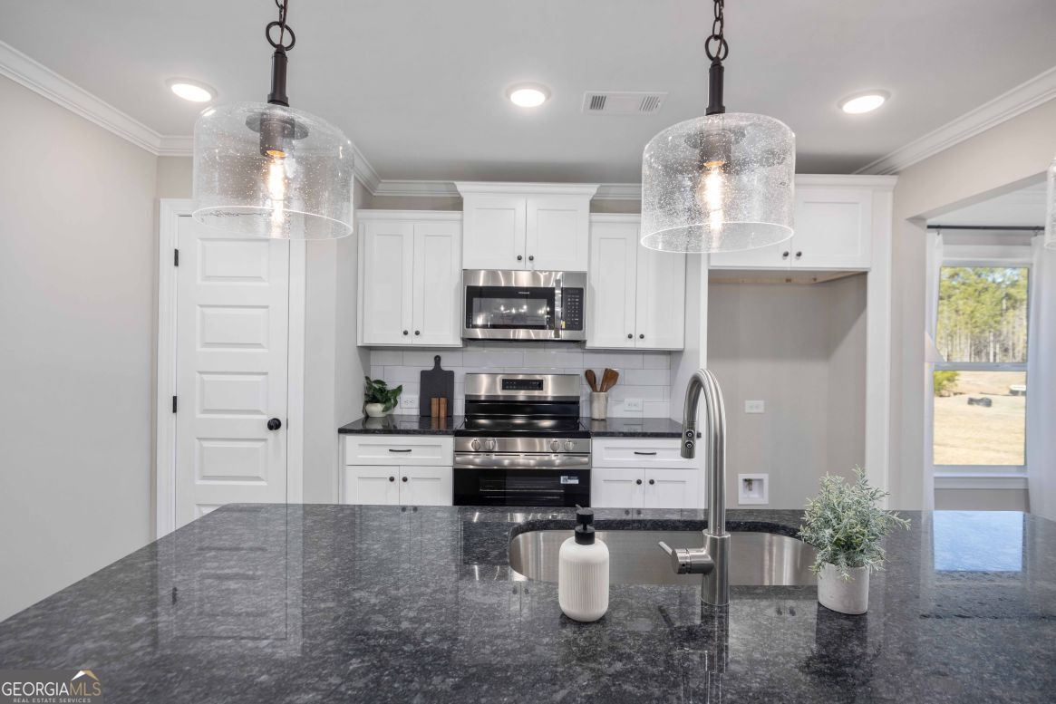 23 Rivers Edge Lane Franklin, GA 30217 - Photo 15 of 32 a kitchen with stainless steel appliances kitchen island granite countertop a refrigerator a stove a sink and a chandelier