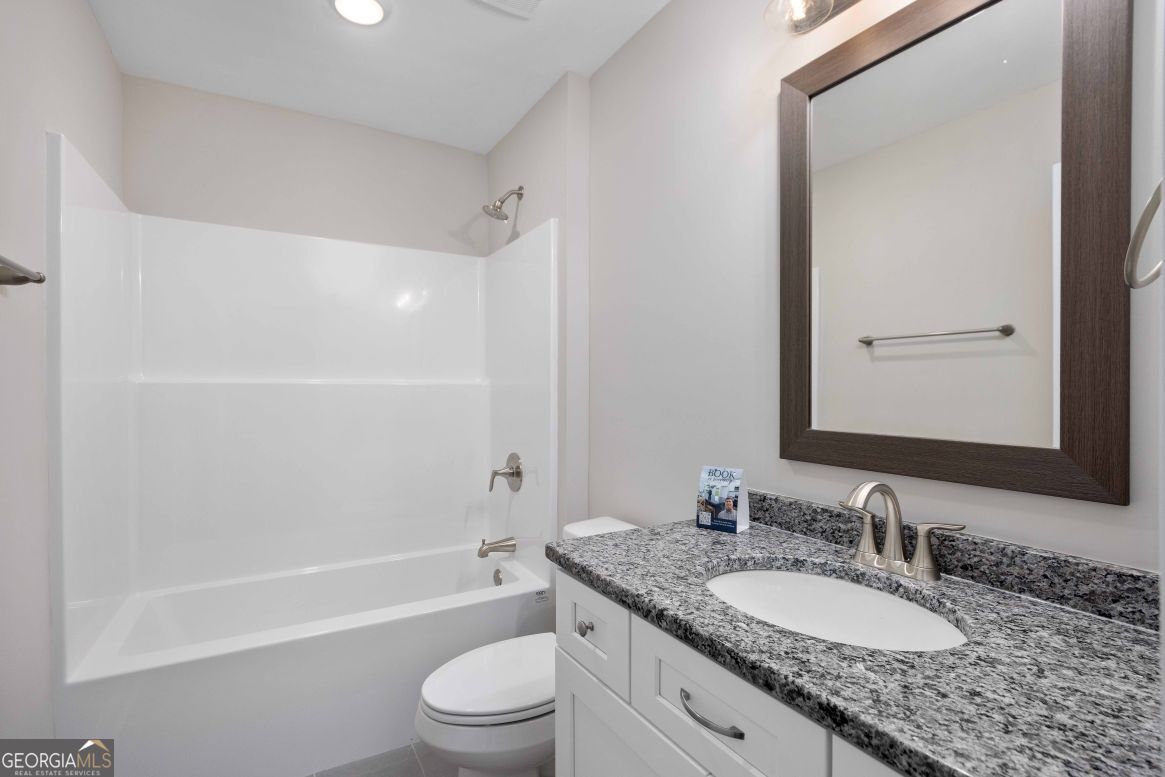 23 Rivers Edge Lane Franklin, GA 30217 - Photo 19 of 32 a bathroom with a granite countertop bathtub shower sink vanity mirror and toilet