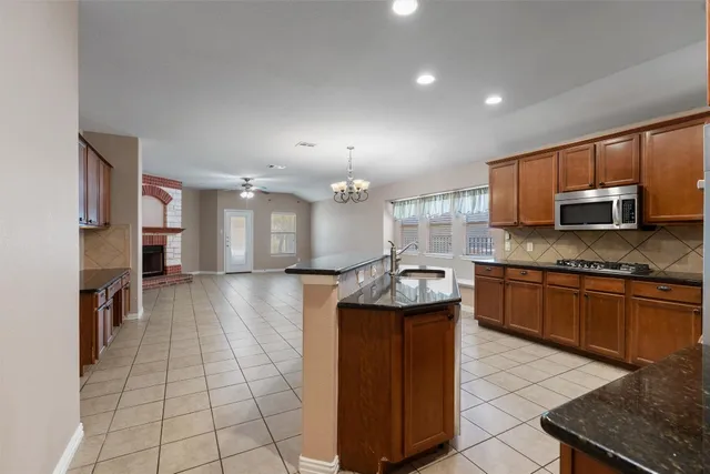 a kitchen with stainless steel appliances granite countertop a stove a sink and a microwave