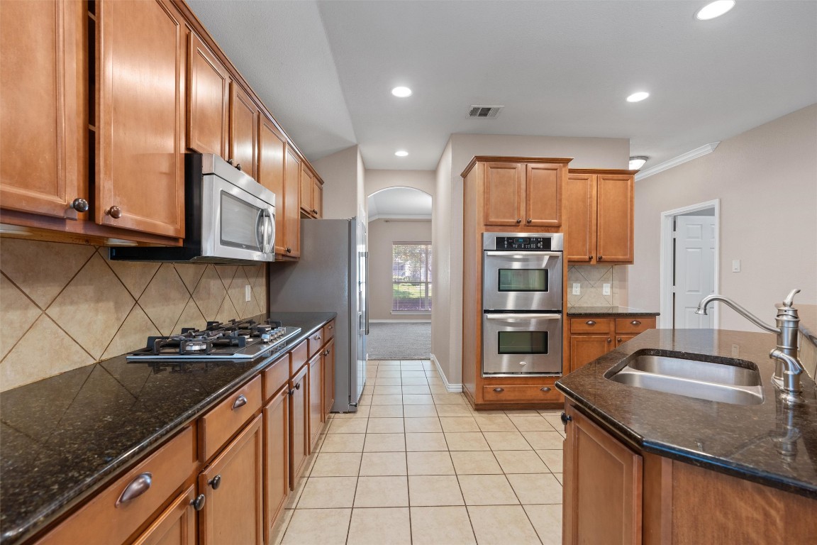 1609 Hidden Springs Path Round Rock, TX 78665 - Photo 6 of 37 a kitchen with stainless steel appliances granite countertop a sink stove and refrigerator