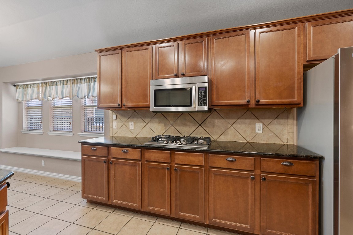 1609 Hidden Springs Path Round Rock, TX 78665 - Photo 8 of 37 a kitchen with granite countertop wooden cabinets and a stove top oven