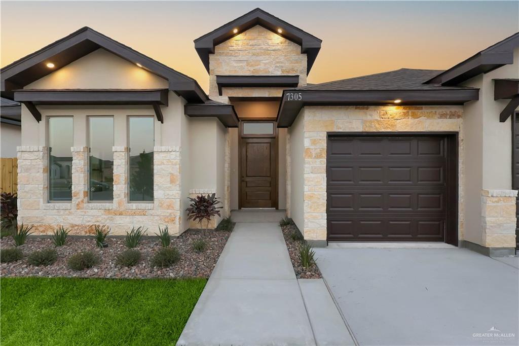 7305 North 55th Lane Mission, TX 78573 - Photo 23 of 26 a front view of a house with a yard and garage