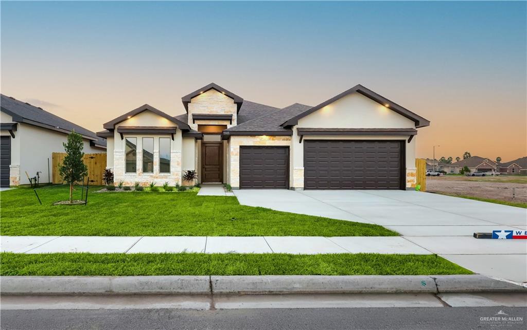7305 North 55th Lane Mission, TX 78573 - Photo 24 of 26 a front view of a house with a yard and garage