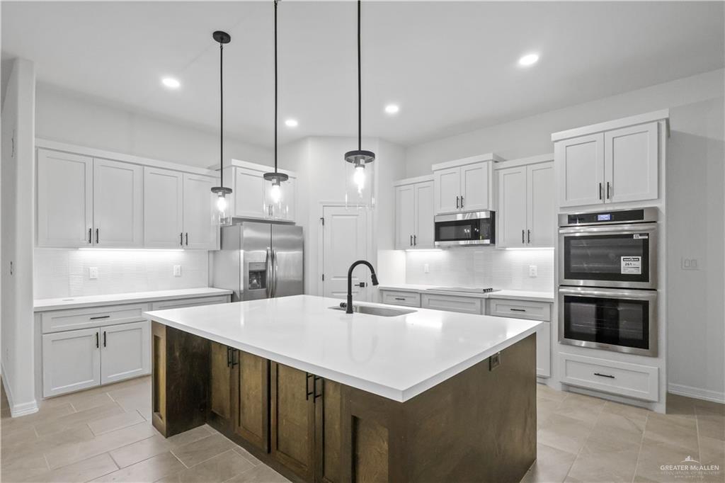 7305 North 55th Lane Mission, TX 78573 - Photo 3 of 26 a kitchen with kitchen island a sink stainless steel appliances and cabinets