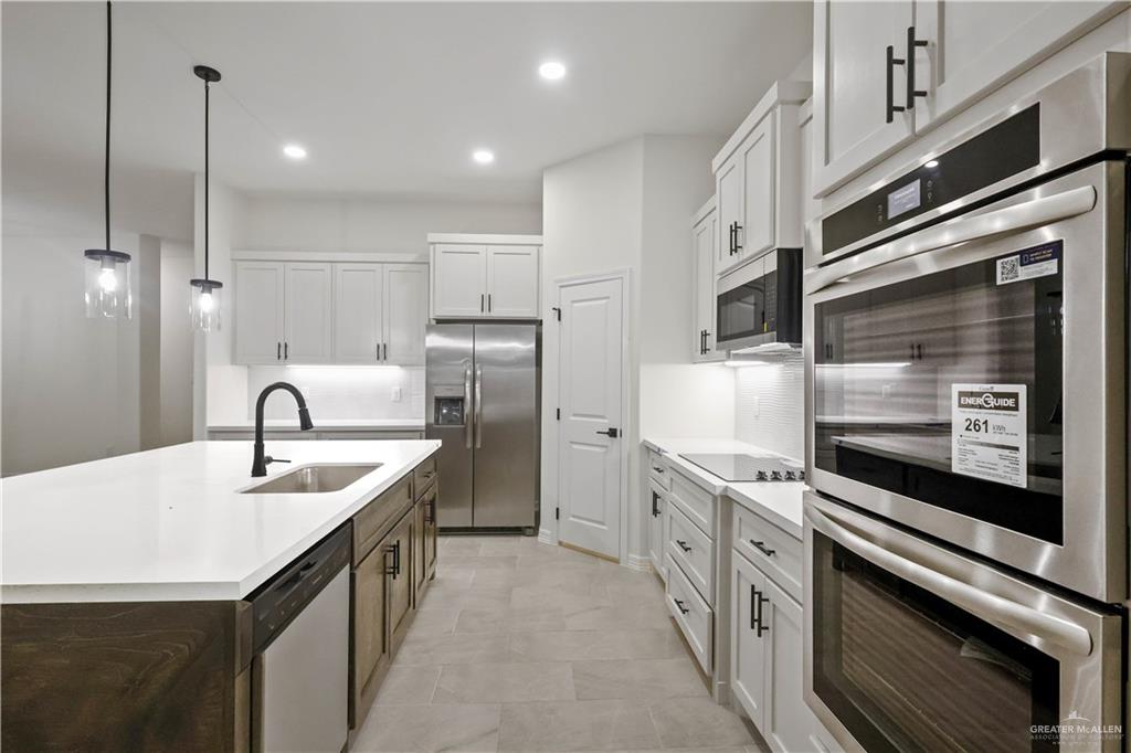 7305 North 55th Lane Mission, TX 78573 - Photo 4 of 26 a kitchen with stainless steel appliances granite countertop a sink a stove and a refrigerator