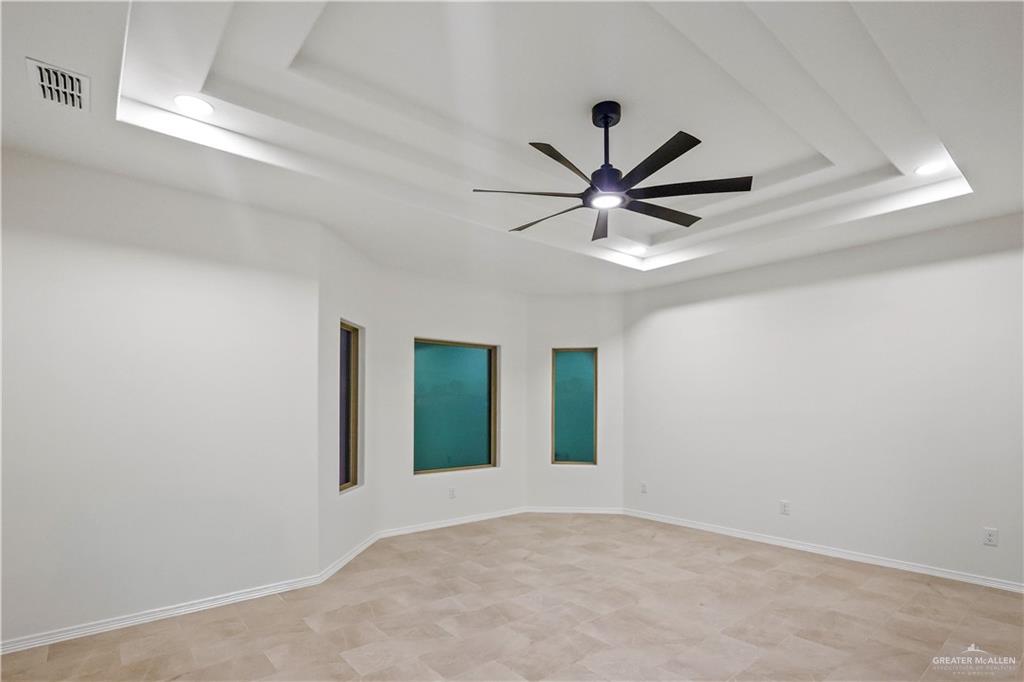 7305 North 55th Lane Mission, TX 78573 - Photo 10 of 26 an empty room with windows and ceiling fan