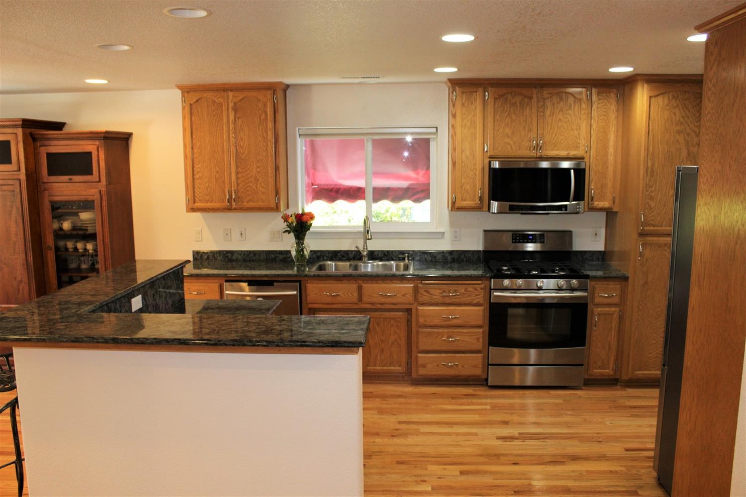 1246 Poppy Ridge Drive Eagle Point, OR 97524 - Photo 10 of 34 a kitchen with stainless steel appliances granite countertop a stove top oven a sink and a granite counter top