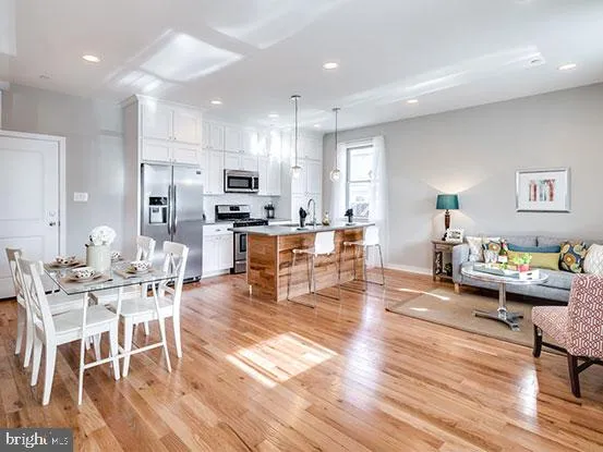 a living room with lots of furniture and kitchen view