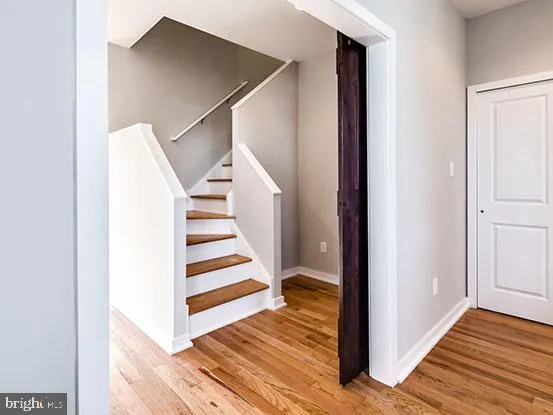 a view of a hallway with wooden floor and staircase