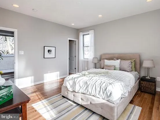 a spacious bedroom with a bed and wooden floor