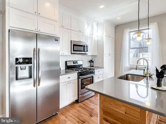 a kitchen with kitchen island a counter space a sink and stainless steel appliances