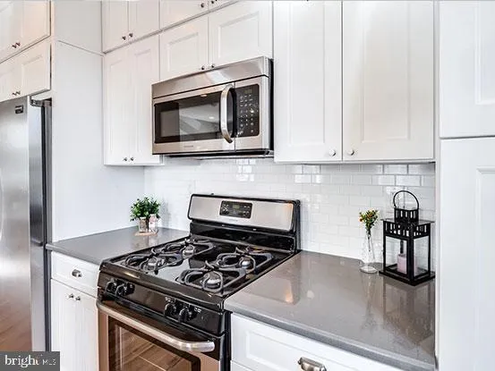 a kitchen with stainless steel appliances a stove a microwave and cabinets