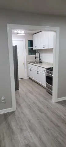 a kitchen with stainless steel appliances a stove a sink and a refrigerator