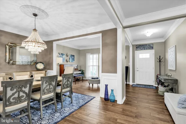 a kitchen with stainless steel appliances granite countertop a stove a refrigerator a sink a stove a dining table and chairs with wooden floor