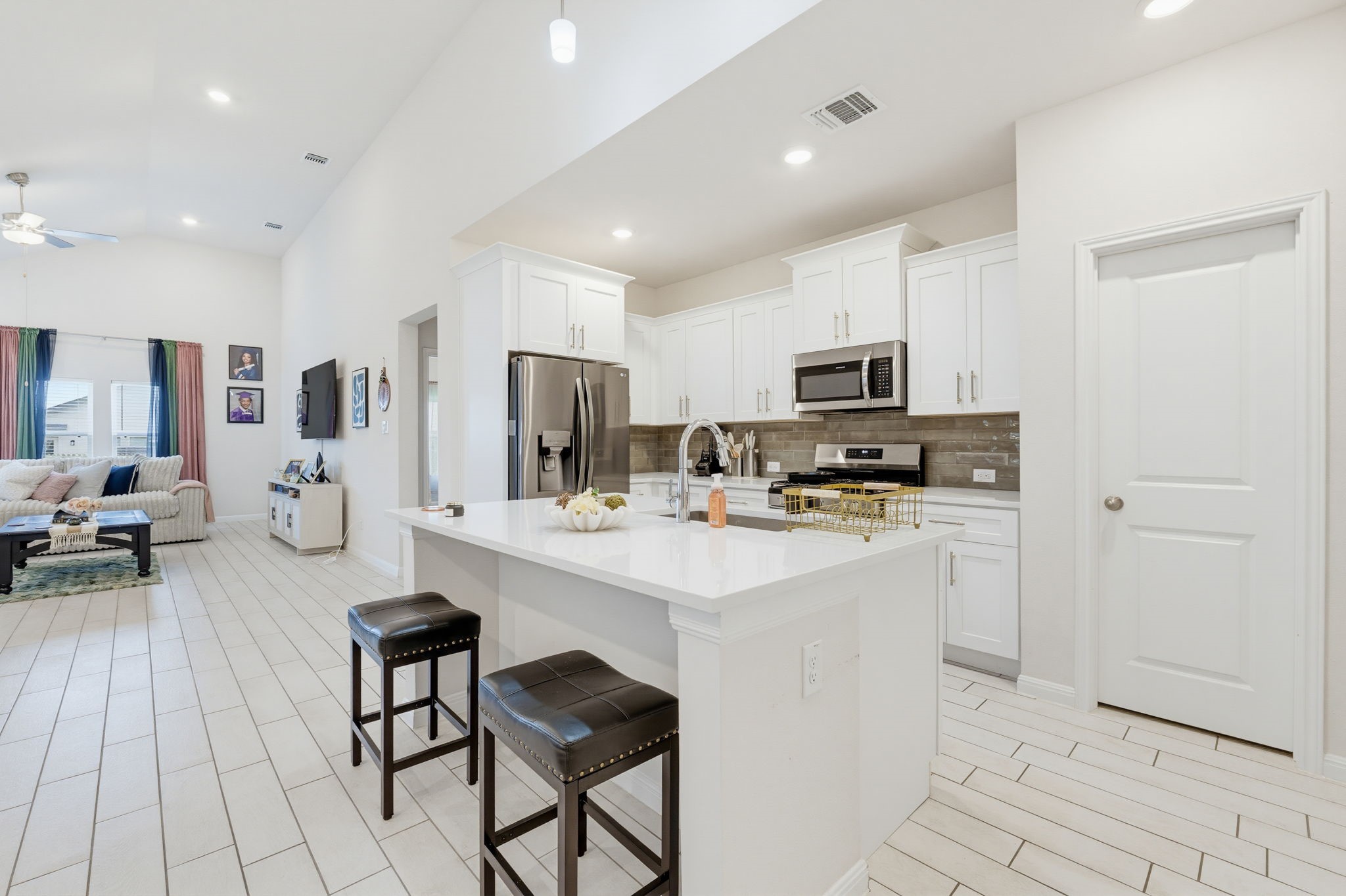 316 Windstar Road Liberty Hill, TX 78642 - Photo 5 of 27 a kitchen with stainless steel appliances kitchen island granite countertop a stove a sink a refrigerator a dining table and chairs with wooden floor