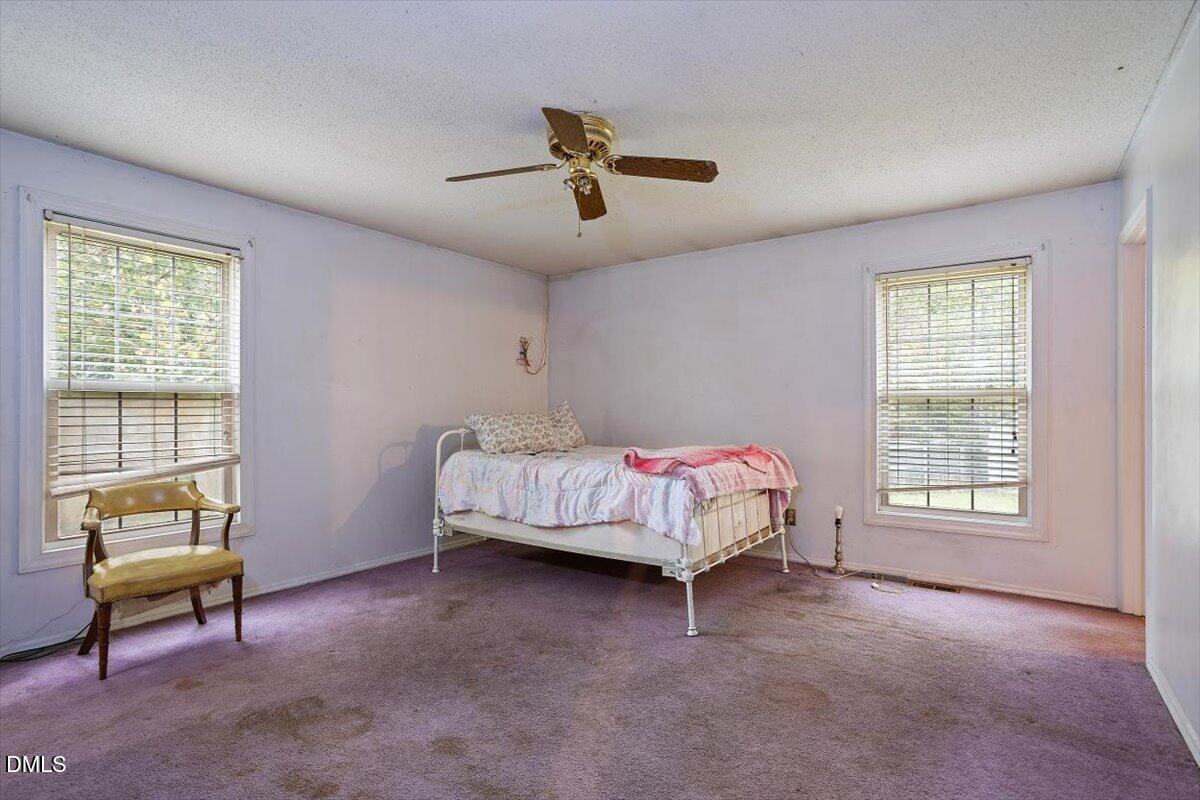 1600 Cranston Road Garner, NC 27529 - Photo 11 of 25 a bedroom with a bed a couch and a window